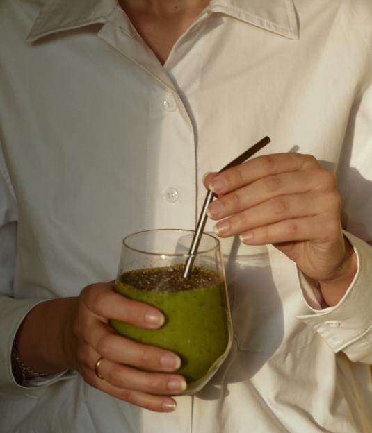 Woman holding a green smoothie