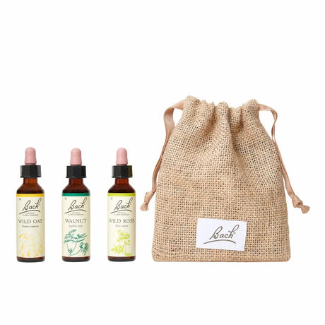 There are three dropper bottles with essences from left to right: Bach™ Original Flower Remedies Wild Oat, Bach™ Original Flower Remedies Walnut and Bach™ Original Flower Remedies Wild Rose. Next to the last essence, there is a burlap bag with the Bach™ logo on it.