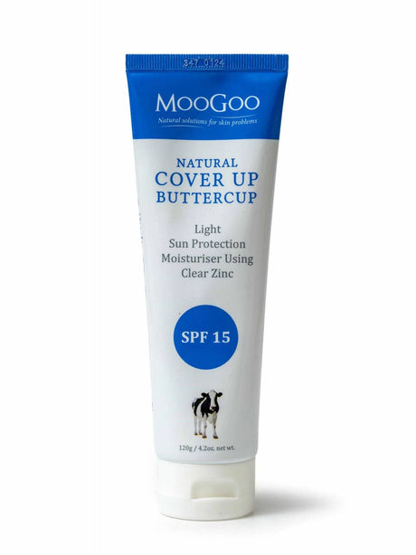 Cream white packaging  with blue colored on the top. The label reads "MooGoo Natural solutions for skin problems, Natural cover up buttercup, light Sun protection Moisturiser using, clear zinc, SPF 15, 120g/4.2 oz. net wt.  