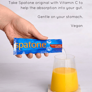 Infographic showing a glass of orange juice and a hand adding one Spatone Sachet and on the top  says" Take Spatone original with Vitamin C to help the absorption into your gut, Gently on your stomach, Vegan"