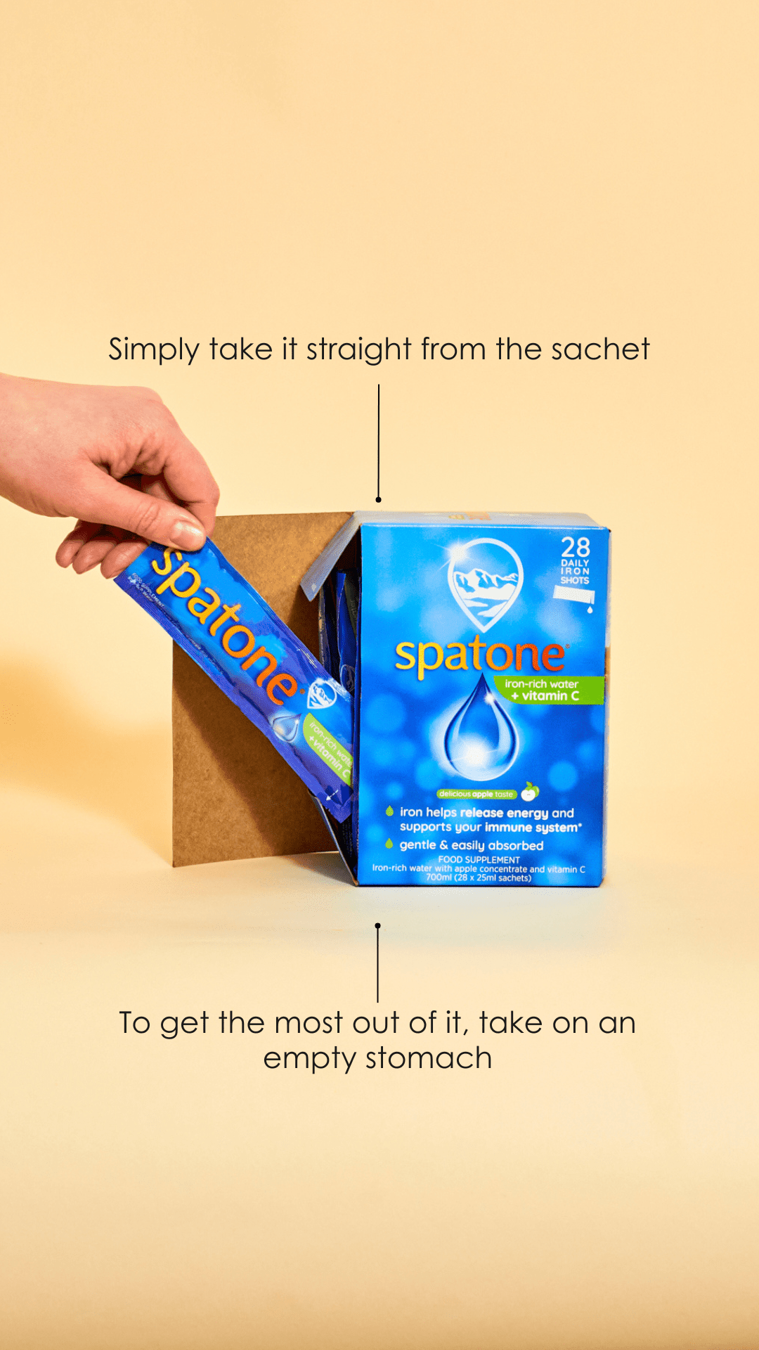 Infographic of a box of Spatone apple 28 day pack  and a hand taking one sachet out of the box, on the top of the box says"Simply take it straight from the sachet" and on the bottom of the box says "To get the most out of it, take on an empty stomach."