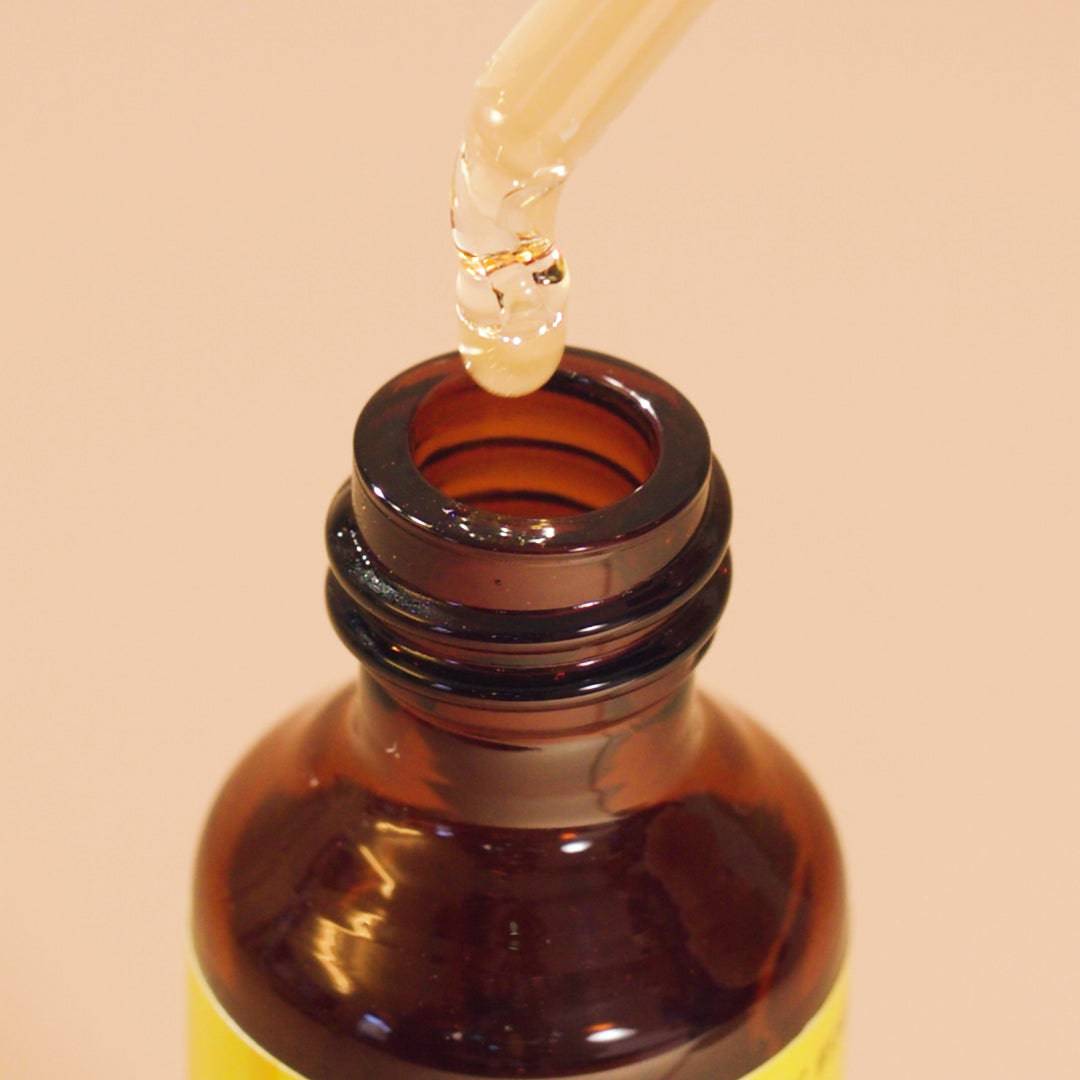 Opened bottle of Rescue® Remedy Dropper and a drop falling from the dropper .
