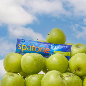 Sky with clouds background, green apples on the front of the image and a sachet of Spatone on the top 