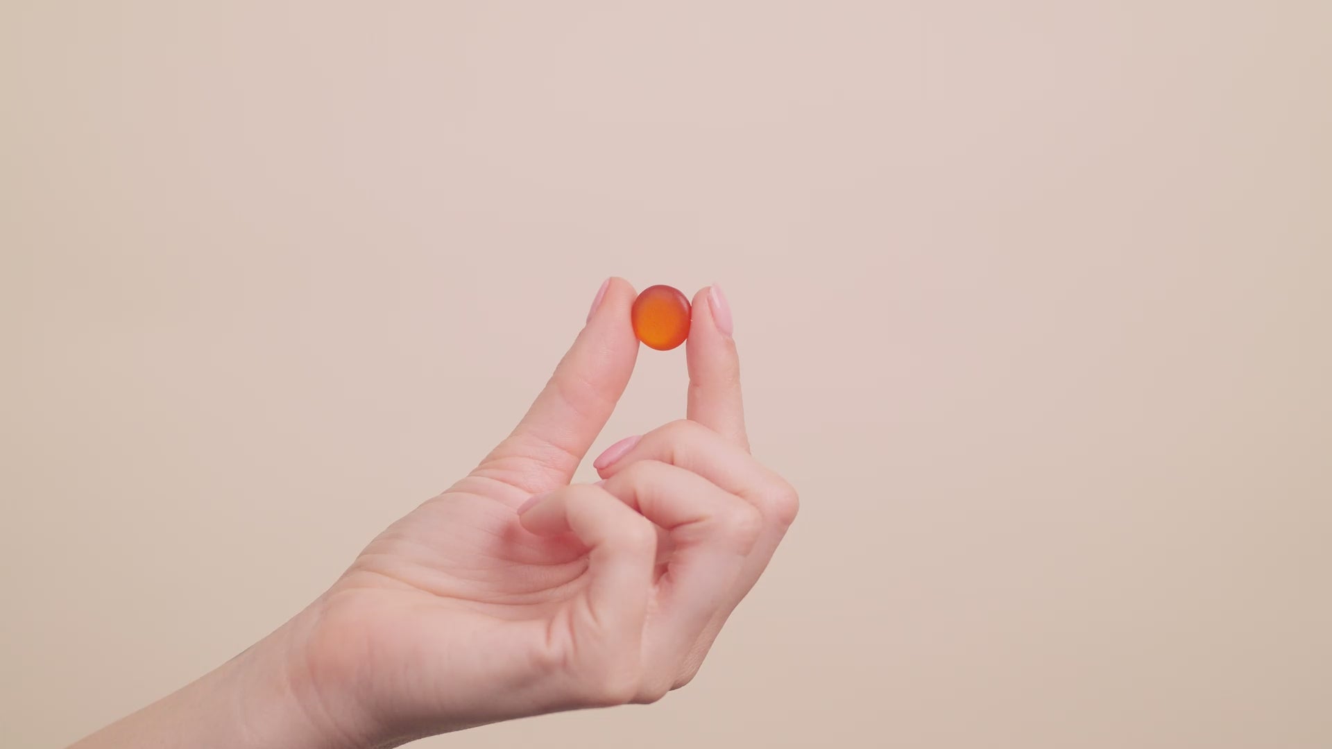 A video of a woman's hand touching a gummie