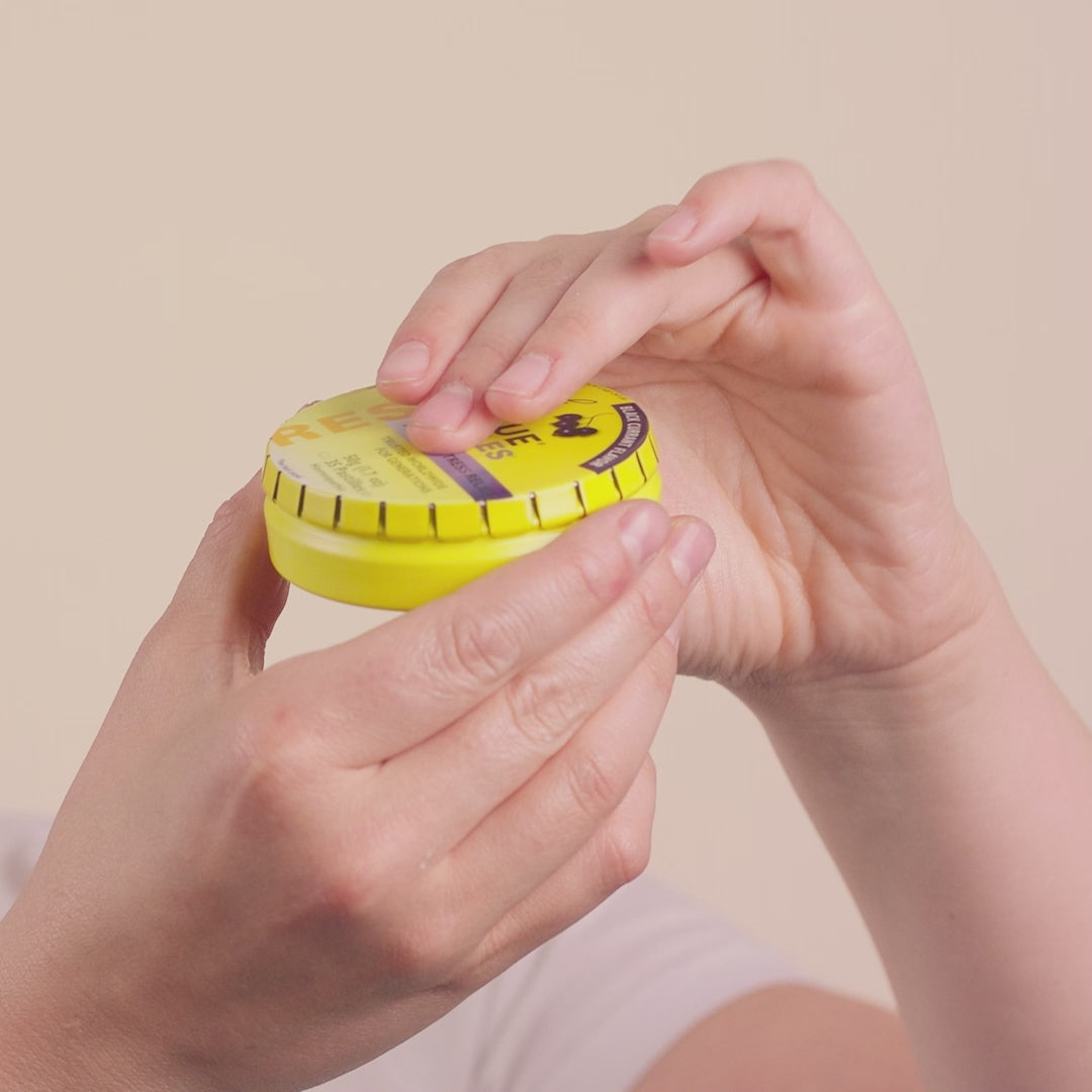 Video of a woman opening a tin of RESCUE® Blackcurrant Pastilles, taking out a pastille and eating it. 