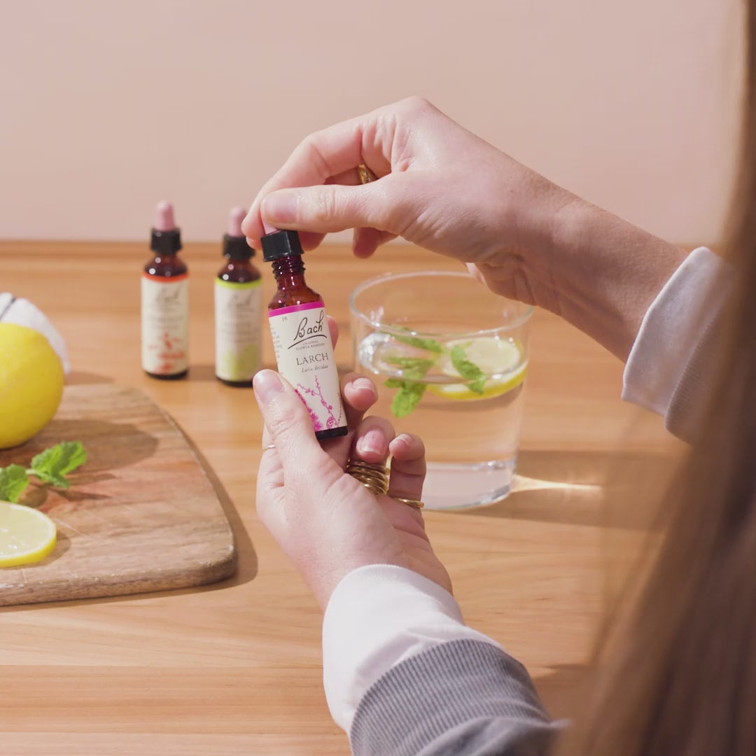 Video of a woman's hands adding a few drops of Bach™ Original Flower Remedy Larch to a glass of water containing a slice of lemon and mint. 