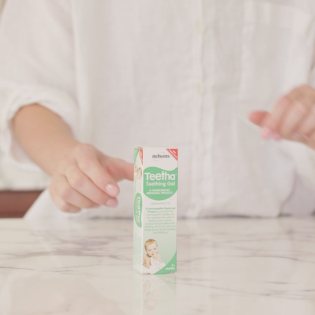 Video of a woman opening the Nelsons Teetha teething gel box, taking the product out of the box and putting some on her finger.